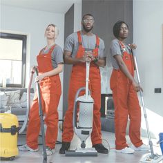 three people in orange jumpsuits are standing next to each other with cleaning equipment