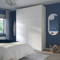 a bedroom with blue walls, white furniture and a large mirror on the wall above the bed