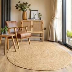 a living room with a rug, chair and potted plant on the side table