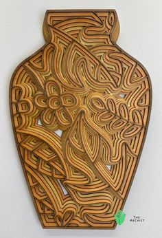 an intricately carved wooden vase is hanging on the wall