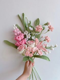 someone is holding a bouquet of flowers on the wall