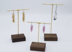 three wooden stands with earrings on them