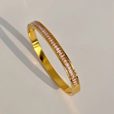 Elevate any outfit with our Pink Zirconia Bangle. Crafted with 18 k gold plating and adorned with pink cubic zirconia stones, this bangle adds a touch of luxury and sophistication. The dazzling stones catch the light, creating a beautiful and eye-catching sparkle. Add this bangle to your other Get Signatured favorites! Length: 17 cm Cubic Zirconia Gold Bangle Bracelet For Party, Pink Gold Plated Bracelets, Party Gold Bangle Bracelet With Cubic Zirconia, Rose Gold Cubic Zirconia Bangle Bracelet, Elegant Pink Gold-plated Bracelets, Pink Cubic Zirconia Crystal Bracelet For Wedding, Elegant Pink Crystal Bracelet With Sparkling Stones, Elegant Pink Diamond Bangle Bracelet, Pink Cubic Zirconia Bangle Bracelets