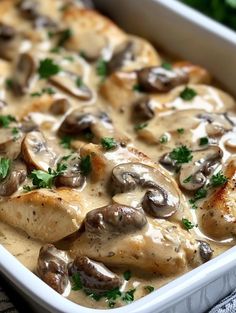 a casserole dish filled with chicken, mushrooms and parsley in a creamy sauce