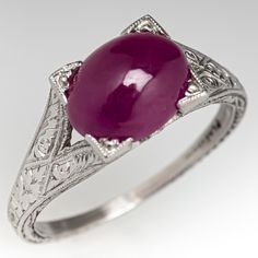 This captivating ring features a pierced and engraved design with milgrain details and is centered with an oval, ruby cabochon, weighing 2.53 carats, in a four-prong setting. The ring measures 7.1mm at the top, rises 7.9mm above the finger, tapering to 1.1mm wide and 0.7mm thick at the base of the shank. This ring is currently a size 5. Vintage Ruby Rings, Antique Cocktail Ring, Ruby Ring Vintage, Ruby Rings, Engraved Design, Ruby Engagement Ring, Red Gemstones, Vintage Jewels, Ruby Ring