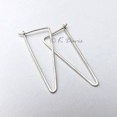 Minimal silver hoop earrings in a geometric triangle. A classic hoop with modern style in a brushed finish. Formed from solid sterling silver wire these triangle earrings have been hammered to emphasize the shape. Then given a brushed finish for a matte look. Two sizes available: Small = 2 cm in length. Large = 3 cm in length. Made from 20 gauge (.81mm thick) solid sterling silver wire. 20 gauge is the standard size for most lightweight hoops. You can enter my shop here: http://www.etsy.com/shop Minimalist Metal Hoop Earrings, Minimalist Geometric Hoop Earrings With Ear Wire, Everyday Silver Triangle Earrings, Minimalist Triangle Hoop Earrings As Gift, Silver Triangle Minimalist Earrings, Minimalist Triangle Earrings For Everyday, Modern Silver Triangle Earrings, Modern Nickel-free Triangle Earrings, Minimalist Triangle Nickel-free Earrings