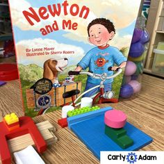 a children's book about newton and me with toys on the table next to it