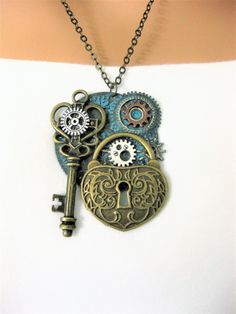 Steampunk lock and key assemblage necklace for women, or men. Handmade jewelry by Ralston Originals. There are two different Steampunk necklaces, see all the pictures. One is made with a large brass clock face, that I put a teal blue patina on. I added a large brass lock charm, a large brass key charm, and silver and copper steampunk gears. The other necklace is made with the same large clock face in antique silver, the large brass cey, and gears, and the lock on this one is brass with a blue pa Metal Key Pendant Jewelry, Key Pendant Jewelry In Metal, Steampunk Jewelry With Keys For Gifts, Vintage Metal Jewelry With Keys Detail, Vintage Metal Key Jewelry, Vintage Metal Jewelry With Keys, Vintage Metal Jewelry With Two Keys, Fair Attire, Steampunk Necklaces