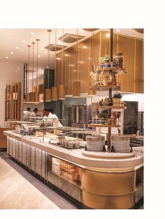 a restaurant kitchen with lots of food on the counter and lights hanging from the ceiling