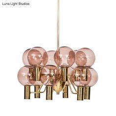 a large chandelier with pink glass balls hanging from it's brass frame