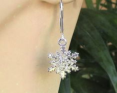 a snowflake earrings is hanging from a mannequin