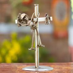 a small metal figurine on top of a wooden table