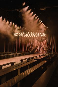 an empty stage with lots of lights and drapes on the curtained area in front of it