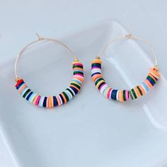 "These are weightless, trendy and so pretty! Gold plated hoops, weightless heishi beads and 2 gold textured beads make these earrings showstoppers! They measure approximately 2\" ." Bohemian Heishi Beads Small Hoop Earrings, Bohemian Small Hoop Heishi Bead Earrings, Nickel-free Heishi Bead Hoop Earrings, Everyday Multicolor Heishi Beads Jewelry, Handmade Colorful Hoop Earrings, Colorful Small Hoop Beaded Jewelry, Colorful Small Hoop Jewelry With Colorful Beads, Trendy Multicolor Heishi Beads Jewelry, Summer Rainbow Heishi Beads Jewelry