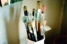 a cup filled with lots of different types of brushes