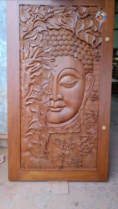 an intricate carved wooden door with a buddha face