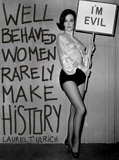 a woman holding a sign that says well, behave women rarely make history