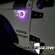 the side view of a white truck with purple lights