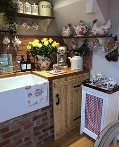 a kitchen area with sink, cabinets and flowers in vases on the wall above it