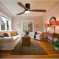 a living room filled with furniture and a ceiling fan in the middle of the room