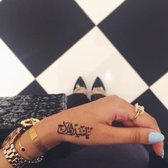 a woman's hand with arabic writing on her left wrist and the word love written in cursive font