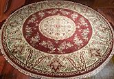 a red and white rug sitting on top of a wooden floor