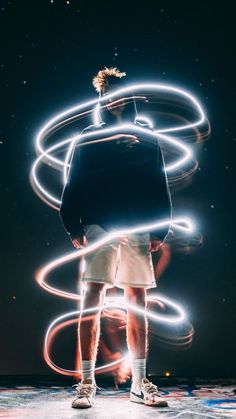 a man standing in front of some lights with his back turned to the camera,