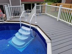 an above ground swimming pool with steps leading up to the deck and over water slide