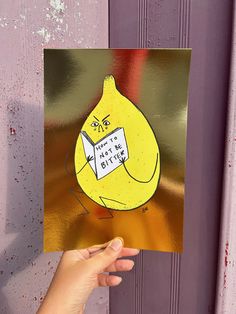 a hand holding up a card with an image of a banana on it that says, do not bite the butter