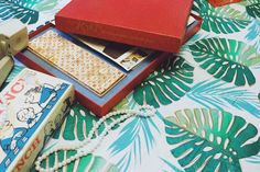 a red box sitting on top of a bed next to other boxes and jewelry items