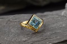 Gold Blue Topaz Ring set with a Natural Blue Topaz in a princess diamond cut with flawless clarity & Sky blue color, sourced from Brazil, at 8x8mm, weighing 3 Carats. Square Ring design made of Gold Vermeil ☞ thickest 18k Gold Plating on top of Solid 925 Sterling Silver ☞ made to last. Matching Earrings: www.etsy.co/listing/1097295321 Matching Pendant - please ask me December Birthstone - Genuine & Natural Stones ❀ ☞ Choose your size ☞ I resize (before shipping) for FREE to Any size* ⌛Last Ring Formal Princess Cut Blue Topaz Ring, Elegant Trillion Cut Topaz Ring Gift, Blue Topaz Ring Gold, Gold Topaz Ring, December Birthstone Ring, Emerald Ring Gold, Sky Blue Color, Square Ring, Real Jewelry