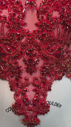 the back of a red dress with sequins on it