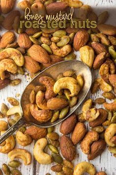 a spoon filled with nuts on top of a wooden table