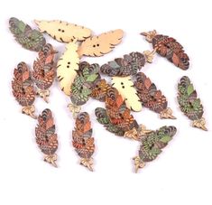 several wooden birds and leaves on a white background