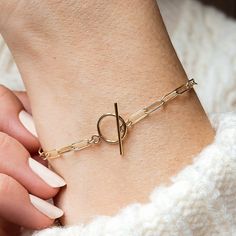 A modern paperclip chain bracelet made entirely from 14k gold fill. An effortless piece to wear with any outfit. Featuring a T-bar clasp and sturdy paperclip chain, this piece is available in a range of sizes for the perfect fit. The paperclip chain bracelet is made in our Leicestershire studio and presented in a bespoke Minetta box, ready for gifting. About Gold Fill: 14k gold filled jewellery has 100+ times more gold than gold plated. Composed of a solid layer of gold bonded with heat and pres Everyday Gold-tone Paperclip Bracelet With Cable Chain, Modern Chain Bracelet With Toggle Clasp For Everyday, Minimalist Gold Paperclip Bracelet With Lobster Clasp, Everyday Gold-tone Paperclip Bracelet With Lobster Clasp, Gold-tone Link Paperclip Bracelet Minimalist Style, Gold-tone Link Paperclip Bracelet In Minimalist Style, Modern Gold-tone Paperclip Bracelet, Modern Paperclip Bracelet With Delicate Chain For Everyday, Everyday Gold-tone Paperclip Bracelet With Rectangular Links