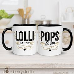 two black and white coffee mugs sitting on top of a counter