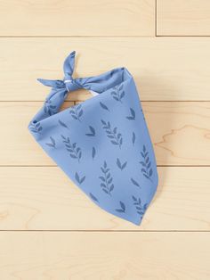 a blue bandana with leaves on it sitting on a wooden floor next to wood planks