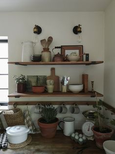 the shelves are filled with pots, bowls and other kitchen utensils on them