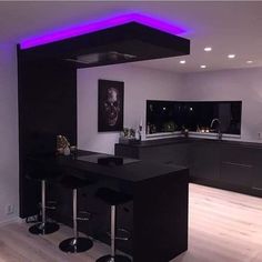 a modern kitchen with black counter tops and bar stools