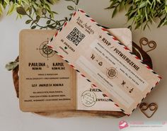 two boarding cards sitting next to each other on top of a wooden tray with plants in the background