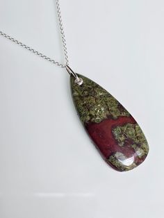 💥 💥 💥 Handcrafted Dragon Blood Jasper pendant with sterling silver details and 18" long sterling silver chain. 🌸 Pendant, including bail: 2" x 0.74" inches/51 mm x 19 mm 🌸 All photos are  enlarged to better view the detailing, please always check the measurements. ✓Because of the natural crystal structure, natural  gemstones could have some small visible scars and crackles. ✓ Solid 925 Sterling Silver (925 parts per 1000) ✓ 925 Silver Hallmarked ✓ Every natural stone is different and exclus Dragon Blood Necklace, Silver Chain Pendant, Dragon Blood, Crystal Structure, Dragons Blood, Jasper Pendant, Chain Pendant, Natural Crystals, Sterling Silber