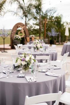 the tables are set with white and purple flowers