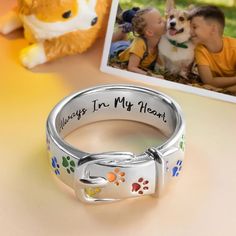 a dog's paw print ring with the words always in my heart on it