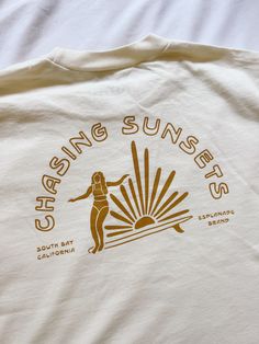 Wouldn't we all rather be chasing sunsets? This women's crop tee in natural with our hand drawn design is going to be your new favorite graphic tee. • Women's Cotton Jersey Crop Tee in Natural with front & back tan print• Set-in ribbed collar and double needle stitching at sleeve• Women's sizing with a fuller contemporary crop fit• 100% combed ringspun cotton 100% NO SWEATSHOPS & ECO-FRIENDLY PRODUCTION Measurements XS S M L XL 2XL Body Length 18 19 20 21 22 23 Chest Width (Laid Flat) 20 21 22 2 Hoodie Business, Printed Tee Women, Graphic Shirt Design, Chasing Sunsets, Surf Tshirt, Sleeves (women), Summer Tshirts, Tee Design, Crop Tee