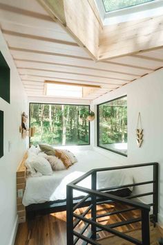 a bedroom with a bed and windows in the ceiling is very small, but it has wood flooring