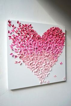 a painting with pink butterflies in the shape of a heart on a white wall above it