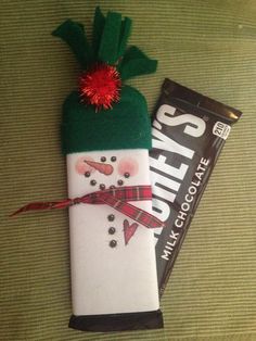 a candy bar wrapped in white chocolate with a snowman on it and a green hat