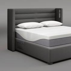 a bed with two pillows on top of it and a night stand next to it