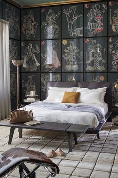 a bedroom with black and white wallpaper has a bed in the middle, two lamps on either side