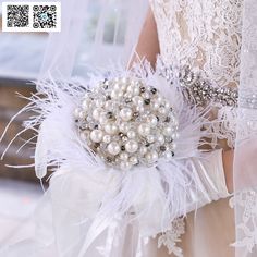 a bridal bouquet with white feathers and pearls